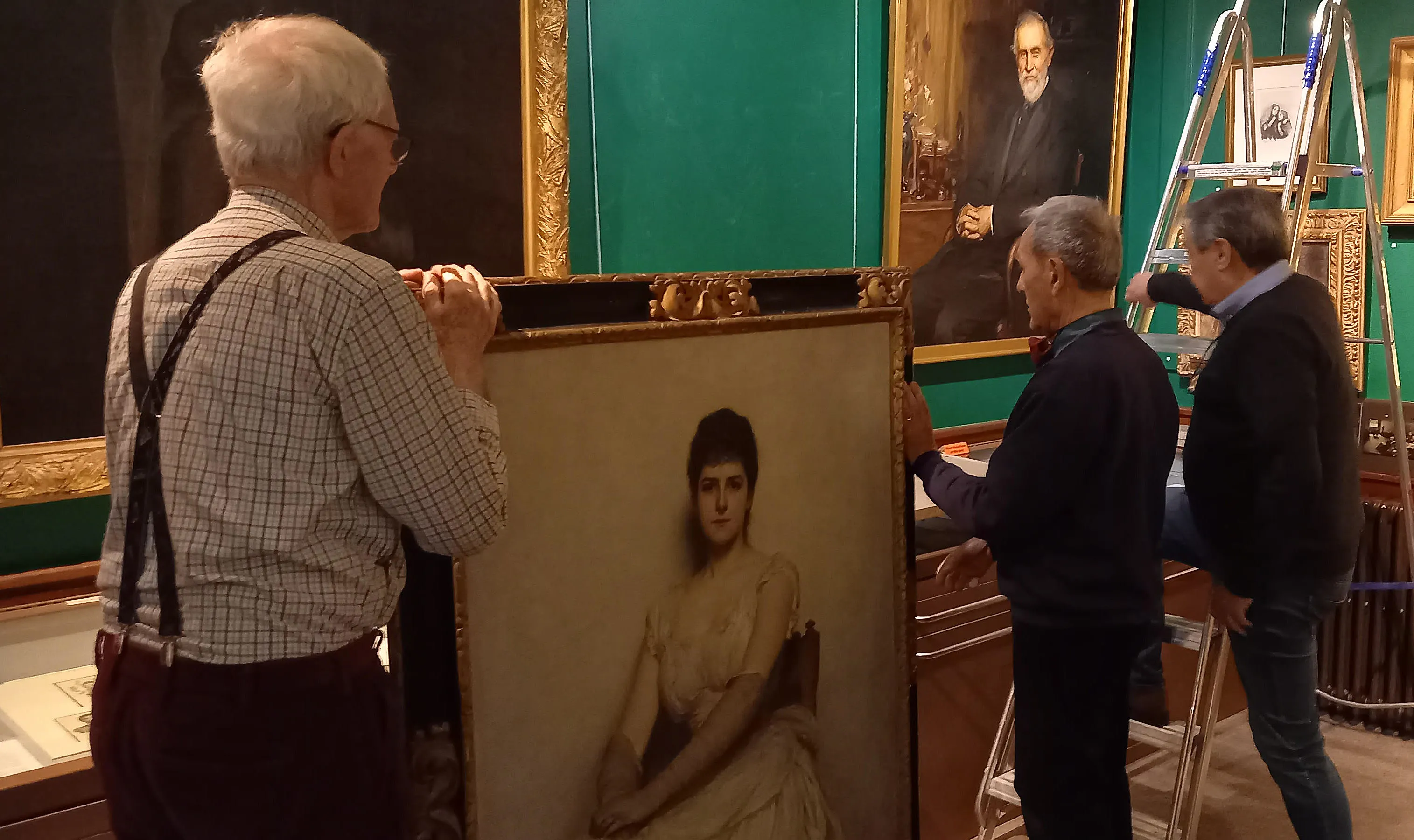 Volunteers prepare to mount the portrait named "Lady in White"